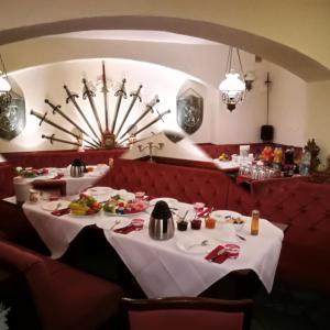 un comedor con 2 mesas y una lámpara de araña en Hotel Zum Goldenen Löwen, en Merseburgo