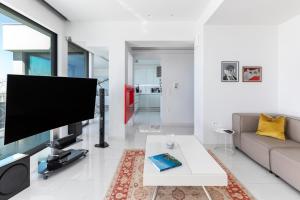 a living room with a large flat screen tv at Aria, Lux seafront apt with White Tower view in Thessaloniki