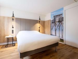 a bedroom with a large white bed and a window at ibis Bordeaux Centre Meriadeck in Bordeaux