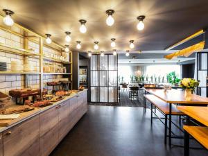 um restaurante com um balcão e uma sala de jantar em Mercure Bordeaux Centre Ville em Bordeaux