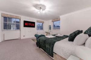 - une chambre avec un lit et une télévision murale dans l'établissement Modern London Luxury 3Bedroom, 3Bathroom Retreat 6, à Londres
