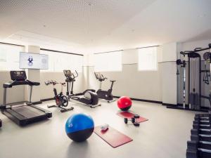 a gym with exercise bikes and exercise balls on the floor at Novotel Campo De Las Naciones in Madrid