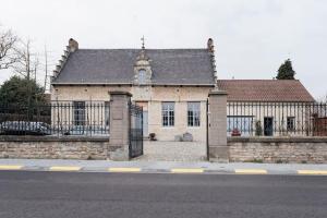 ein altes Backsteingebäude mit einem Tor davor in der Unterkunft Van Hamme 1642 - house for 2 to 4 persons in Kortenberg