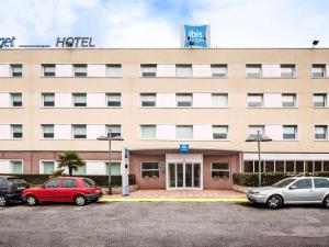 een hotel met auto's voor het hotel bij Ibis Budget Barcelona Sant Andreu De La Barca in Sant Andreu de la Barca