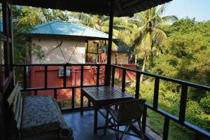 un patio con tavolo e sedia sul balcone di Wild Grass Resort a Port Blair