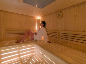 a woman sitting on the inside of a sauna at Mercure Jelenia Góra in Jelenia Góra