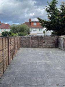 a backyard with a wooden fence and a house at Cozy Home in Twickenham