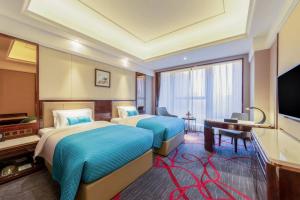 Cette chambre comprend deux lits et une télévision. dans l'établissement Xi'an Lanxi International Hotel, à Xi'an