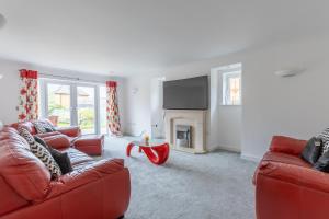 a living room with a red couch and a fireplace at Supreme Class Properties in Eastchurch