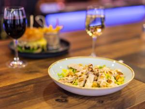 a bowl of food on a table with wine glasses at ibis London City - Shoreditch in London