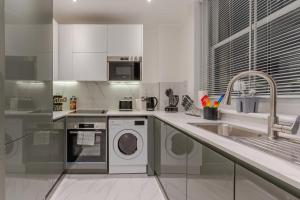 a kitchen with a washing machine and a sink at Modern London Luxury 3Bedroom, 3Bathroom Retreat 6 in London