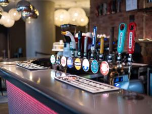 a bar with a bunch of bottles on a counter at ibis London City - Shoreditch in London