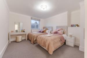 a bedroom with two beds and a desk at Modern London Luxury 3Bedroom, 3Bathroom Retreat 6 in London