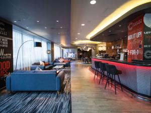 a hotel lobby with a bar with couches and a counter at ibis London City - Shoreditch in London