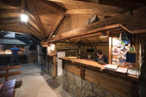a woman sitting at a counter in a restaurant at Camping Drina in Foča