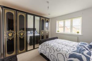 a bedroom with a bed and a large dresser at Supreme Class Properties in Eastchurch