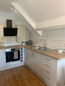 a kitchen with white cabinets and a sink at The White Hart Apartment Valley View in Alton