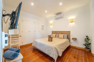 a bedroom with a bed and a flat screen tv at Lost Lobster Guest House in Albufeira
