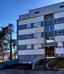 Un grand bâtiment avec des escaliers en face de celui-ci dans l'établissement Citykoti, à Varkaus
