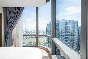 ホーチミン・シティにあるIsabelle Luxury Apartment inside Landmark 81 Towerのベッド1台と大きな窓が備わる客室です。