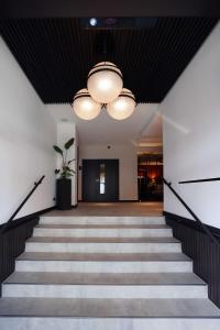 a hallway with stairs and a chandelier at Best Western Plus Hotel St. Raphael in Hamburg