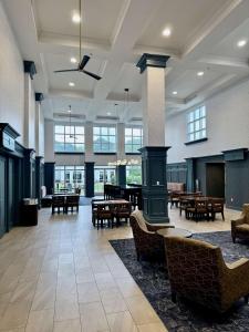 a lobby with tables and chairs in a building at Hampton Inn & Suites West Little Rock in Little Rock
