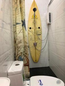 Baño con tabla de surf en la pared junto a un aseo en Blue ocean, en Ko Samed