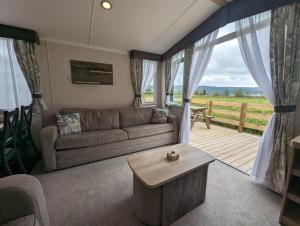 un soggiorno con divano e tavolo di Swift Bordeaux Sea View No 3 a Dunoon