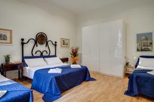 una camera con due letti con lenzuola blu di Otium Maecenatis Apartments a Roma