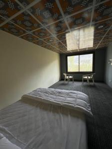 a bedroom with a large bed and a window at Hostel Nomads Hunza in Alīābād