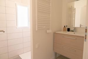y baño con lavabo y ducha con espejo. en La Vie En Gîte (Le Scandinave), en Sainte-Florence