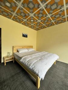 a bedroom with a bed and a coffered ceiling at Hostel Nomads Hunza in Alīābād