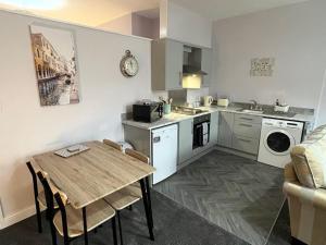 a kitchen with a table and a dining room at The Print Room, 1 Bedroom Ground Floor Apartment in Carlisle
