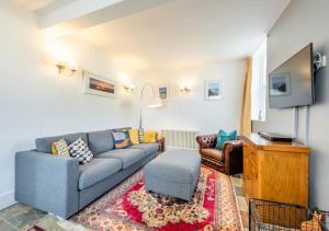 a living room with a blue couch and a tv at South Street Farm in Braunton