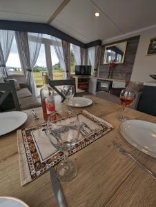 a wooden table with wine glasses on top of it at Swift Bordeaux Sea View No 3 in Dunoon