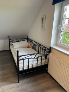 a black bed in a room with a window at Deichbrise in Greetsiel