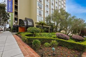 a garden in front of a building with bushes and flowers at Comfort Inn By the Bay in San Francisco