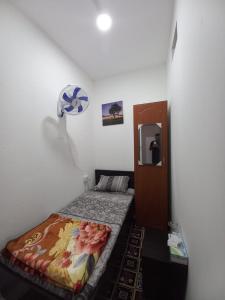 ein kleines Schlafzimmer mit einem Bett in einem Zimmer in der Unterkunft oNLY MALE GENDER ROYAL LUXURY PARTITION SMALL ROOM in Abu Dhabi