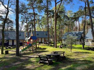 un parque con mesa de picnic y parque infantil en Domki Polskie Morze, en Pobierowo