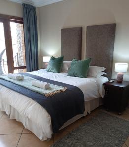 1 dormitorio con 1 cama grande con almohadas verdes en Tonder High Performance Center en Pretoria