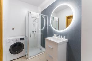 a bathroom with a sink and a washing machine at Aquamarina Prima Deluxe Studios With Sea View by Renters in Międzyzdroje