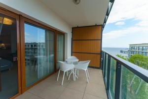 a balcony with white chairs and a view of the ocean at Aquamarina Prima Deluxe Studios With Sea View by Renters in Międzyzdroje