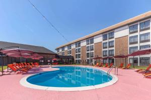 a hotel with a swimming pool with chairs and a building at Comfort Inn & Suites Aberdeen in Aberdeen