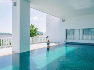 a little girl sitting in the water in a swimming pool at Novotel Phuket City Phokeethra in Phuket Town