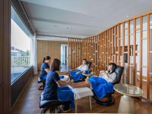 a group of people sitting in chairs in a room at Novotel Phuket City Phokeethra in Phuket Town