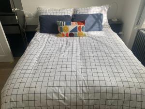 a bed with a checkered blanket and pillows on it at Beautiful 58 sqm Apartment Zone 2 in London