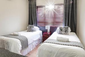 2 camas individuales en una habitación con ventana en Tonder High Performance Center en Pretoria