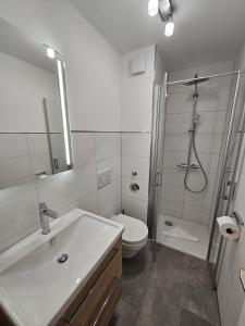 La salle de bains est pourvue d'une douche, de toilettes et d'un lavabo. dans l'établissement Elbstrom 09, à Döse