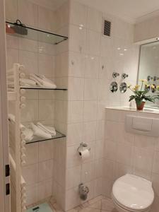 y baño con ducha, aseo y espejo. en Haus Metropol App 103, en Westerland
