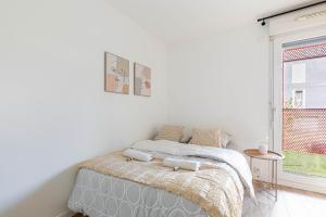 um quarto branco com uma cama e uma janela em GuestReady - Chic Hideaway near Paris em Saint-Ouen
